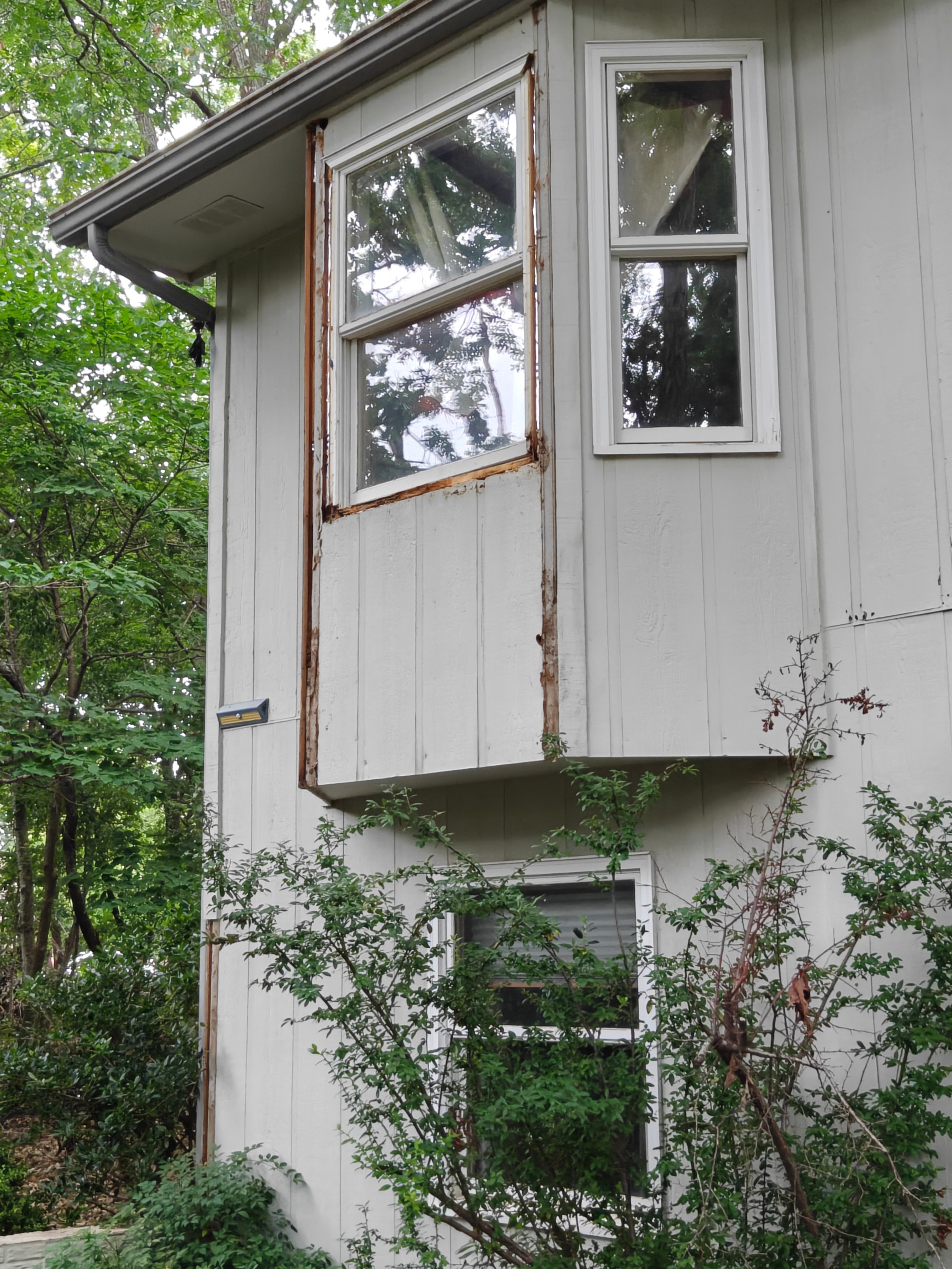 Bay window frame and trim with rot and peeling paint before repair in Bella Vista
