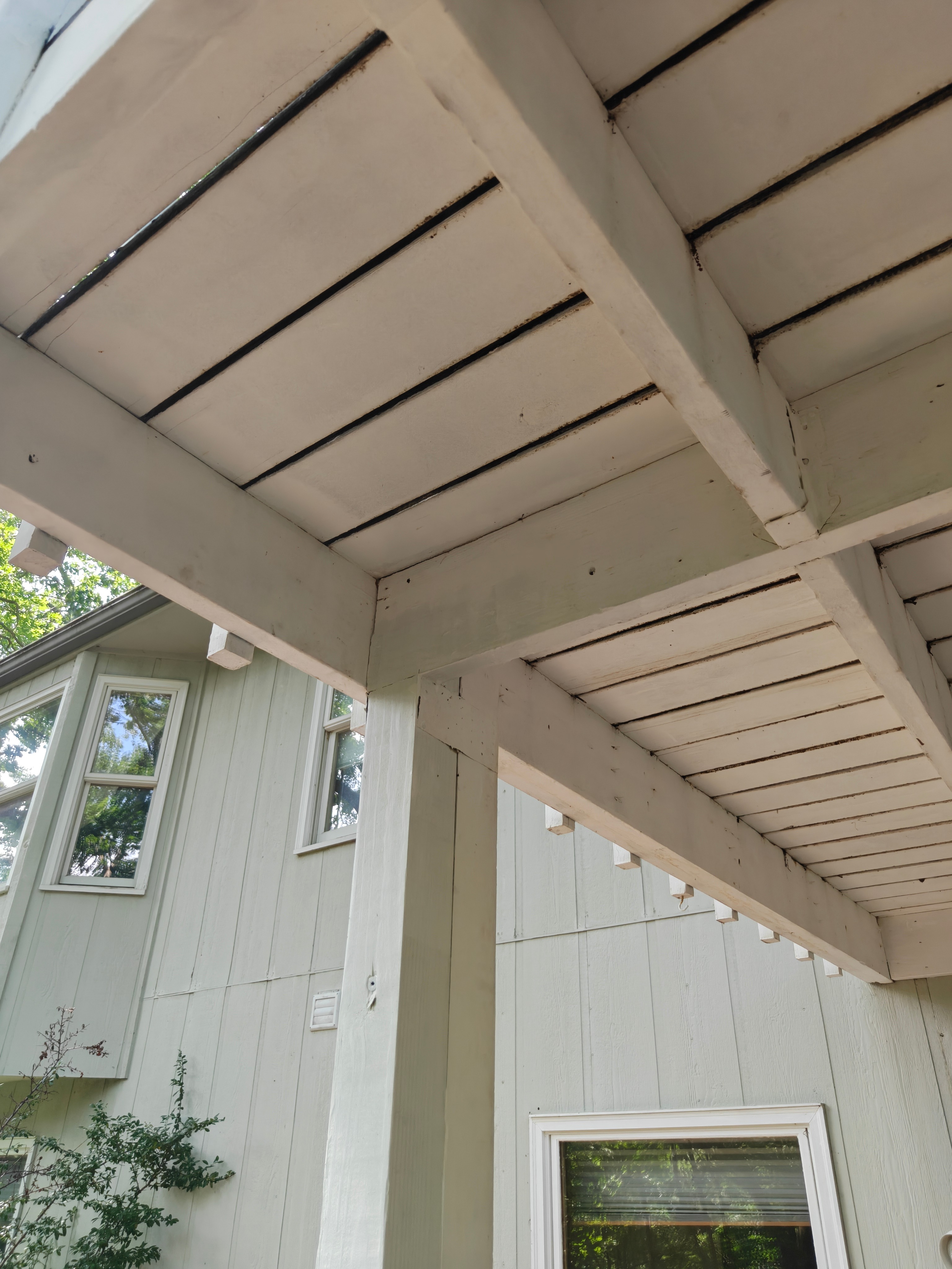Repaired and freshly repainted porch ceiling and soffit boards after trim work in Bella Vista