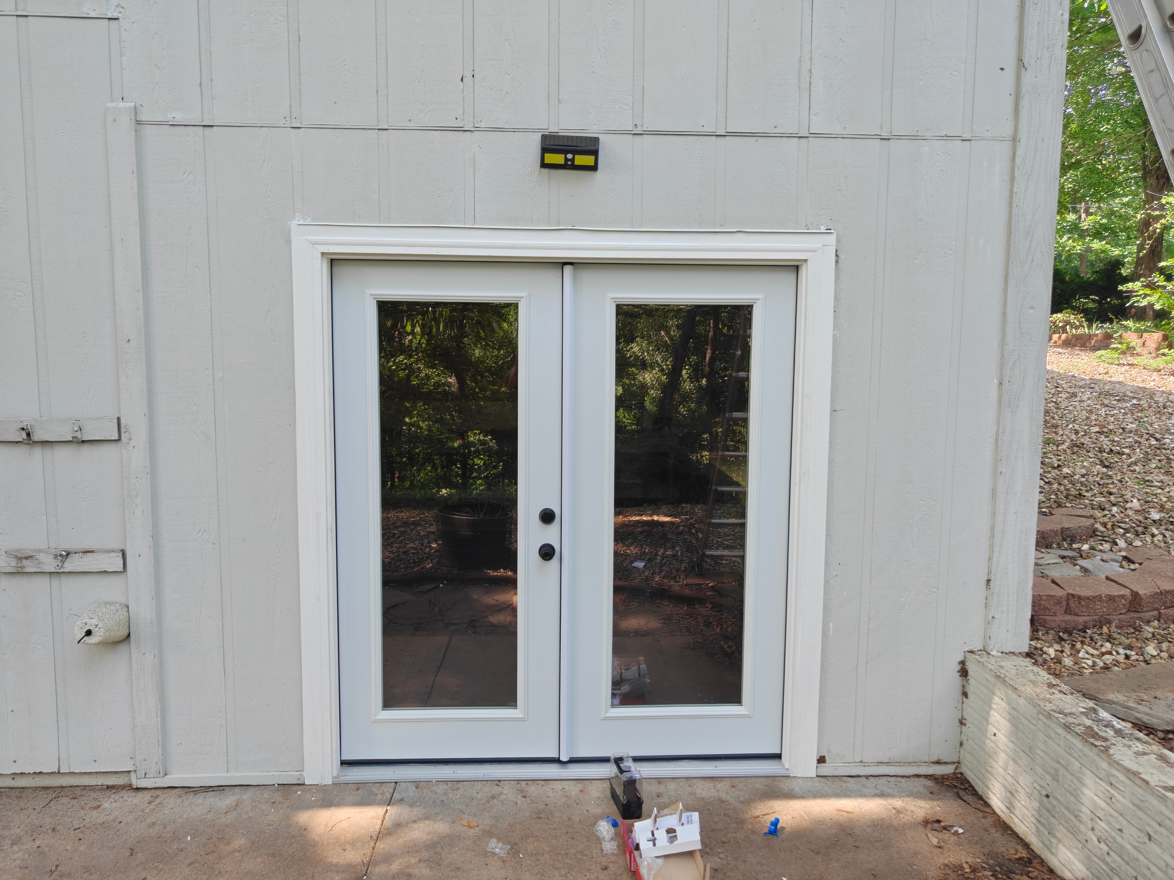 New white double French patio doors installed on home exterior in Bella Vista