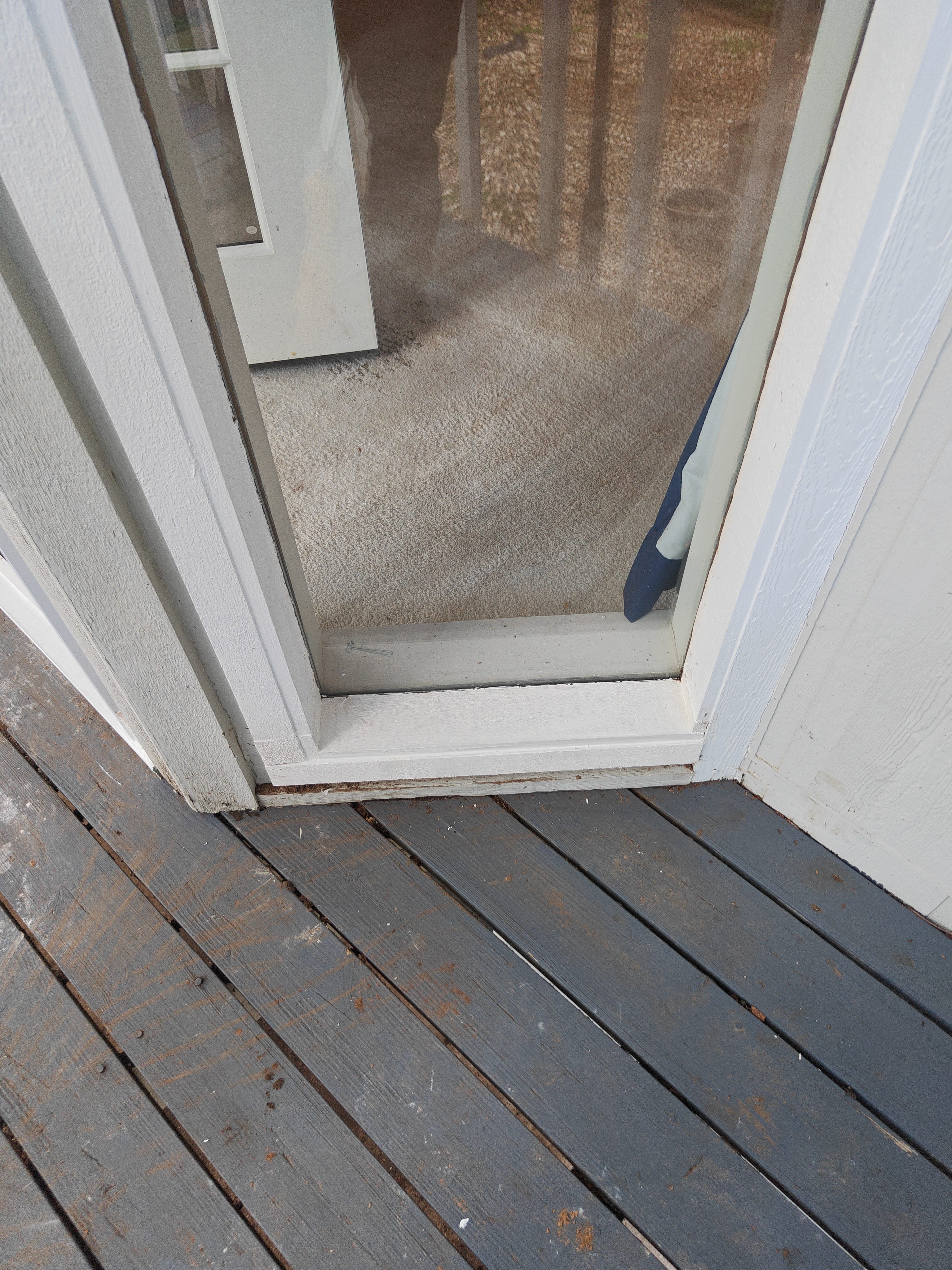 Rotted exterior door threshold and trim with debris before replacement in Bella Vista